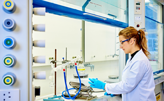 female chemical engineering conducting testing with goggles.